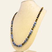 Necklace with blue and brown beads on a mannequin bust against a white background