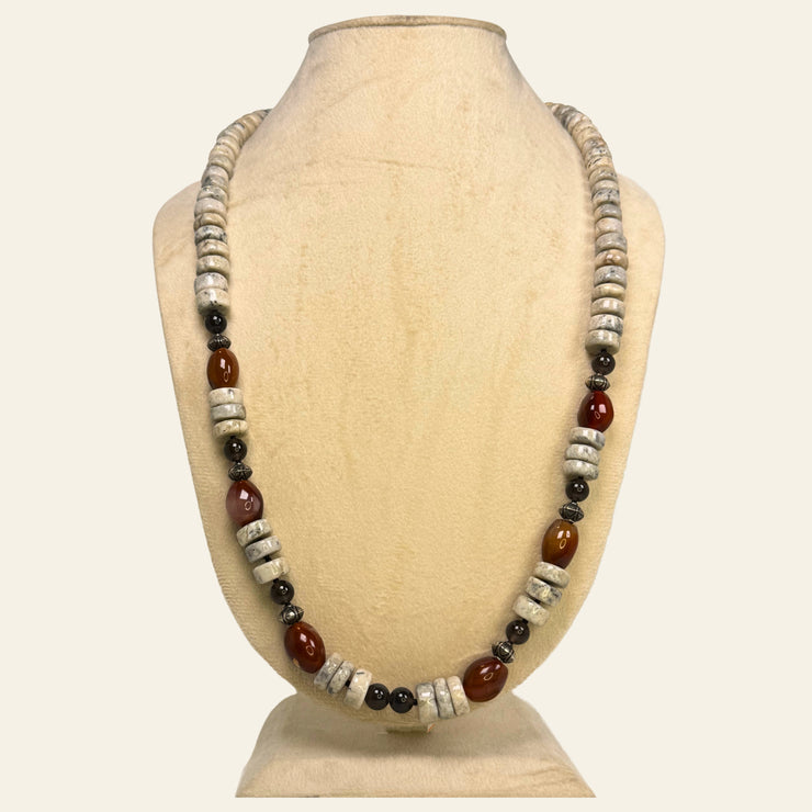 Necklace with brown and white beads on a beige mannequin bust_ tiger eye beads_tribal and contemporary