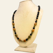 Necklace with multicolored beads on a mannequin bust against a white background