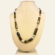 Necklace with brown and white beads on a beige mannequin bust_ tiger eye beads_tribal and contemporary