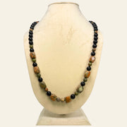 Necklace with multicolored beads on a mannequin bust against a white background
